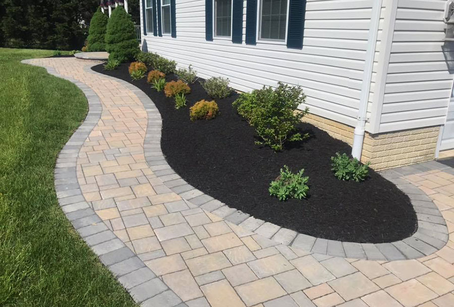 Image of a flowing hardscaped walkway and a planting installed by JM Landscaping