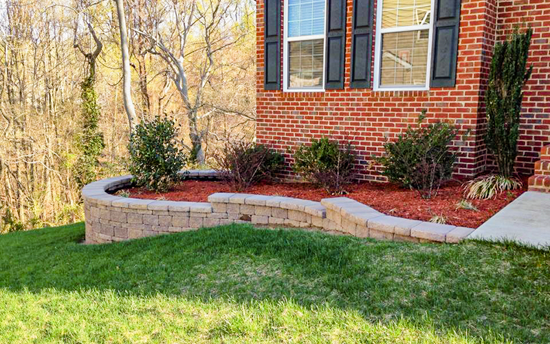 Image of raised bed wrapped with a hardscape edging installation.